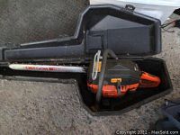 Husqvarna 61 chainsaw placed in its black storage case.