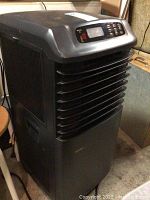 Full view of black Danby 3-in-1 portable heater, air conditioner, and dehumidifier unit with vented front and top control panel.
