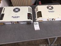 Both amplifiers side by side on a table