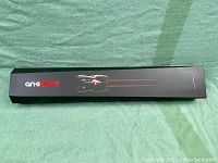 Long rectangular black box with 'Anki Drive' branding and image of a racing car on top, placed on green fabric surface.
