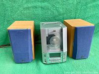 Overall front view of JVC Compact Component System FS-V30 with both speakers showing the wood finish and blue fabric grills