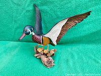 Full view of the carved and painted duck sculpture mounted on a wood base, showing the detailed carving and paintwork.