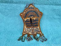 Full view of antique 1909 beadwork match holder on blue felt background
