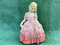 Front view of Royal Doulton porcelain figurine 'Rose' depicting a blonde girl in a pink ruffled dress.