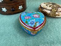 Blue porcelain heart-shaped trinket box with floral design and gold trim shown from above