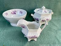 Three Ridgway porcelain items: footed bowl, cream pitcher with repaired handle, hexagonal sugar bowl with lid, all decorated with mulberry floral patterns, shown from front side.