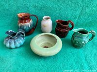 Photo showing all five vintage pottery pieces together: four pitchers/jugs and one bowl with hole.