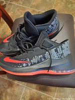 Lateral side view of black and red Nike Air Max Infuriate men's sneakers size 13 showing mesh upper and Air Max cushioning in sole.
