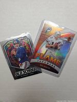 Photo showing Eli Manning Old School Mosaic card and Dan Marino Flame Throwers card in protective plastic sleeves.