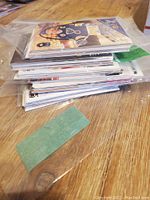 Stack of multiple hockey player cards on wooden surface, some in plastic sleeves, view shows a variety of cards with different players.