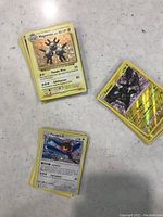 Stacked and loose assorted Pokémon trading cards laid on a table featuring Magneton and Porygon-Z cards in focus