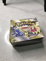 Pokémon Neo Genesis display box closed, showing front artwork with Heracross, Pichu, Meganium