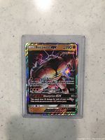 Holographic Buzzwole GX Pokémon card front in protective plastic sleeve
