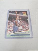 Front of the 1992 Shaquille O'Neal rookie card showing him playing basketball in Orlando Magic uniform, card number 323.