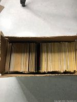 Top-down view of cardboard box filled with stacked trading cards