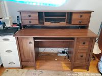 Front view showing desk with top hutch, drawers, cabinet, and keyboard pull-out.