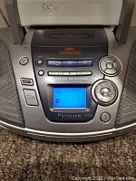 Close-up of Panasonic RX-ES29 control panel showing buttons, digital display showing 'NO TAPE', and speaker grilles on sides.