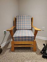 Front view of solid wooden chair with blue plaid cushions on seat and backrest.