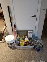 View of the lot showing painting supplies in plastic bins, paint pail, extendable poles, and box of grout