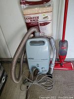 Kenmore 3500 canister vacuum with hose, vacuum bags in original packaging, and Vileda floor mop with red handle