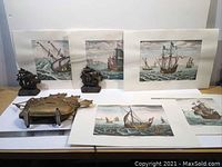Lot containing a ship lamp, two ship bookends, and five hand-colored naval engravings depicting historic ships.