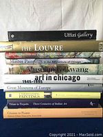 Stack of 11 art museum and painting related books including Uffizi Gallery, The Louvre, Impressionism and Post-Impressionism, and other titles.