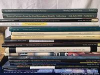 Photo showing spines of 15 hardcover art sale catalog books with titles from Christie's and Sotheby's.