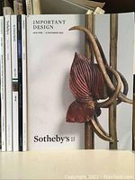 Front covers of various auction catalogues, with focus on Sotheby's 'Important Design' 2018 catalogue featuring floral sculpture on cover.