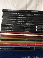 Stack of 14 Joyner Canadian Art sale catalogs with visible dates from 1988 to 2011 in various color softcover formats.