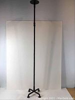 Full view of the tall wrought iron candle holder showing its height and simple design.