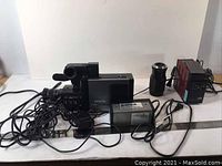 Full view of the Zenith camera with attached cables, battery pack, power supply box, and additional lens shown on a white surface.