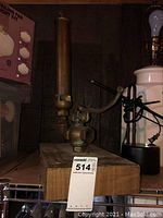 Full view of brass steam whistle mounted on wood base