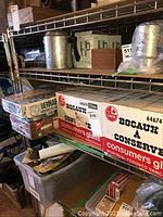 Shelf with multiple boxes of Consumers Glass canning jars, one box showing the label Bocaux à Conserve and Canadian origin.