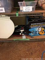 North Star 3 million candle power searchlight box, showing product label and five frying pans stacked with black or dark handles.