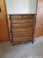 Front view of wooden dresser with six drawers, showing drawer hardware and overall design.