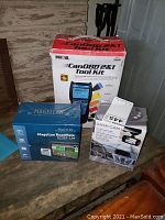 Overview photo showing all three boxes: Magellan GPS, Innova CanOBD2 Tool Kit, CJ Tech Dash Cam.