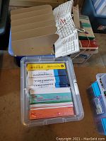 Three bins including a metal file divider, a Microsoft white ergonomic keyboard, and multiple 500-sheet reams of letter-size paper from Hammermill and HP.