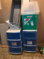 Two rolling storage drawer units, one green Rubbermaid bin without lid, small clear bin with lid and open storage shown.