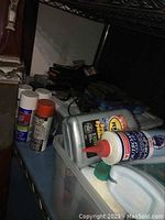 Motor oils, spray paint cans, and repair products on a shelf
