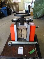 Front view of entire rolling mill atop wooden dolly with caster wheels