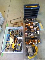 Full overview of the lot showing hand tools, the plastic container with screws and parts, saws, clamping tools, and assorted fasteners.