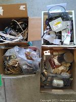 Four boxes filled with assorted electrical cables, computer components, and miscellaneous parts shown from above.
