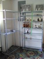Two assembled metal wire shelving racks side by side in a corner, one loaded with decorative items