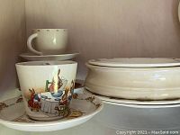 Photo of Bunnykins cup and saucer with rabbits eating and playing, showing surface design and rim of cup and saucer