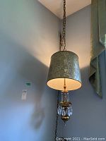 Full view of hanging lamp with chain, metal shade and crystal prisms