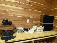 Wide view showing camera, lenses, leather case, Sunpak video light box, Bauer charger box and speakers