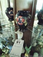 Front view of the vase on glass shelf revealing full floral design