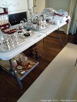 Full side view of the folding table with various items placed on top showing condition and leg structure.