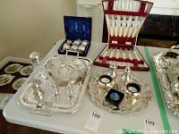 Overview of silver-plated trays, two-tier serving dish, and flatware in red case