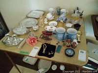 Photo showing the entire assortment on table including mugs, trays, teacups, figurines, candle holders, and jewelry.